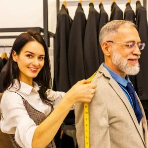 a-professional-tailor-woman-trying-on-a-tailor-mad-JYQWNKK